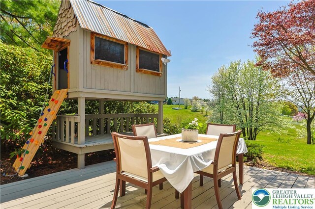 wooden deck featuring a yard and outdoor dining space