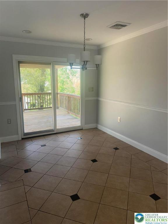unfurnished dining area with baseboards, tile patterned flooring, ornamental molding, and visible vents