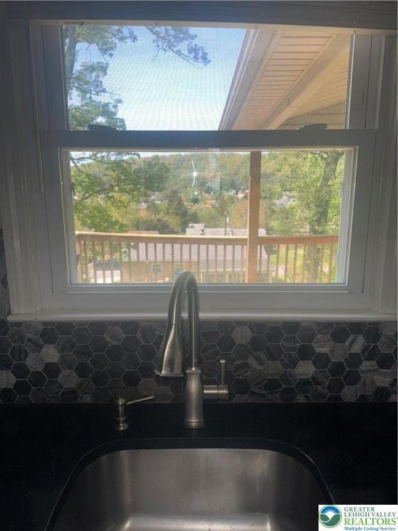 interior details with a sink, decorative backsplash, and white cabinets