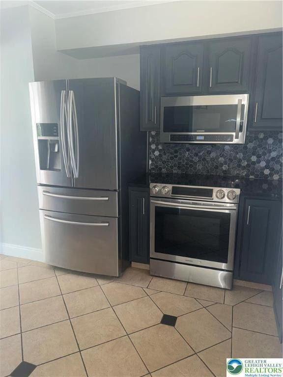 kitchen with ornamental molding, backsplash, light tile patterned floors, and stainless steel appliances