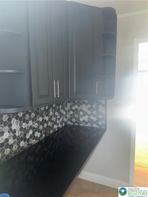room details with crown molding, baseboards, and backsplash