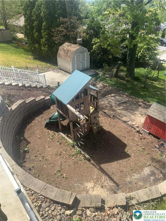 view of yard featuring a playground, a storage unit, and an outdoor structure