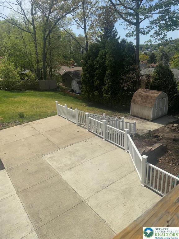 view of patio with an outbuilding and a storage unit
