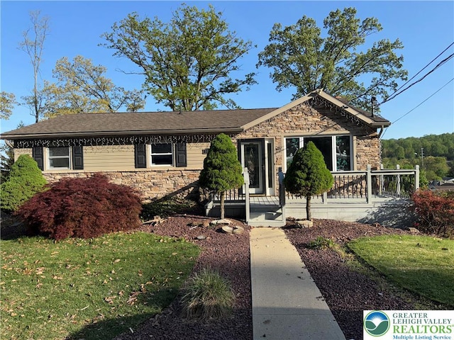 single story home featuring a front lawn and stone siding