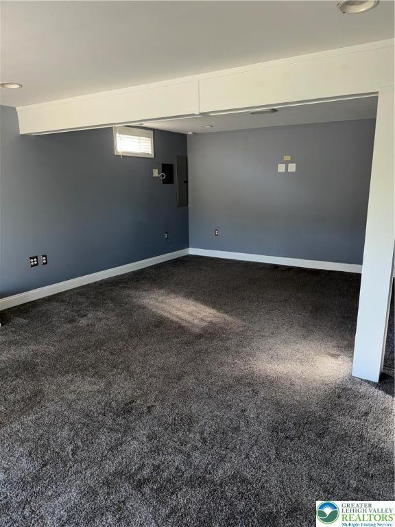 empty room featuring dark carpet and baseboards