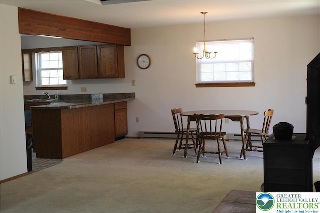 95 Piney Woods Dr, Penn Forest Township, PA 18229 - kitchen featuring an inviting chandelier, dark countertops, hanging light fixtures, and light colored carpet