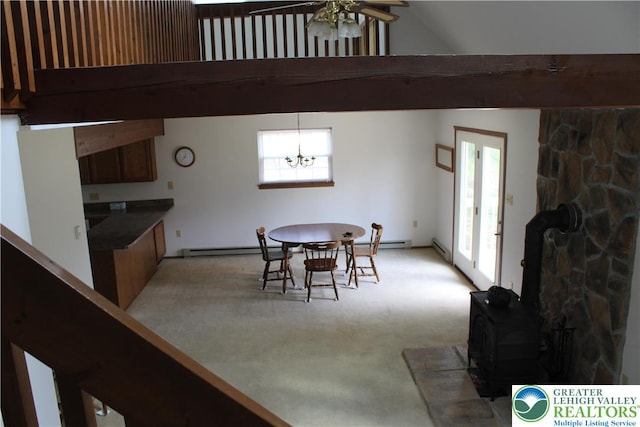 95 Piney Woods Dr, Penn Forest Township, PA 18229 - dining space featuring a baseboard radiator, plenty of natural light, a wood stove, and ceiling fan with notable chandelier
