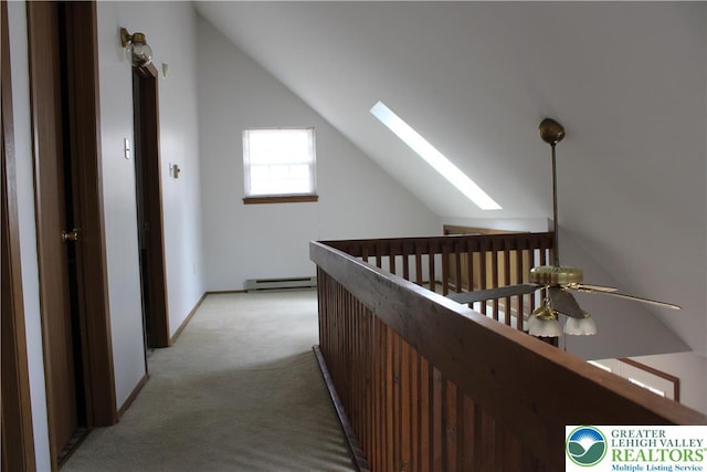 95 Piney Woods Dr, Penn Forest Township, PA 18229 - corridor featuring vaulted ceiling with skylight, a baseboard radiator, and light carpet