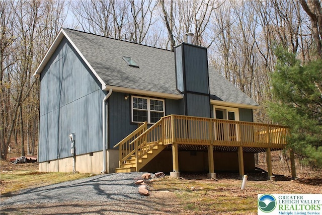 95 Piney Woods Dr, Penn Forest Township, PA 18229 - rear view of house featuring roof with shingles, a wooden deck, and a chimney