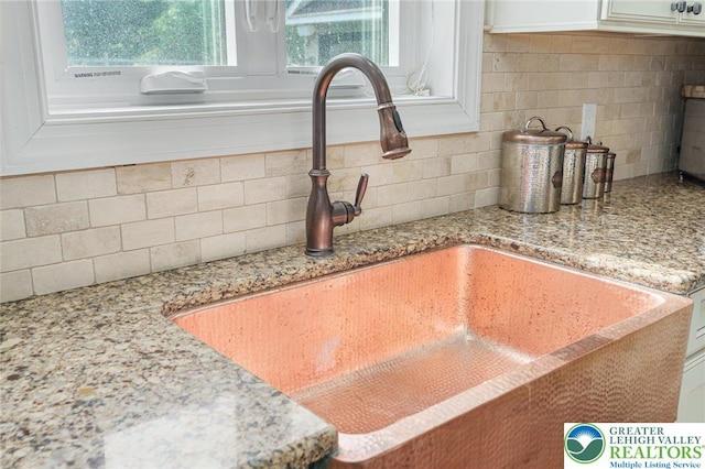 4164 Tank Farm Rd, Upper Milford Twp, PA 18049 - interior details with light stone counters, a sink, white cabinetry, and backsplash