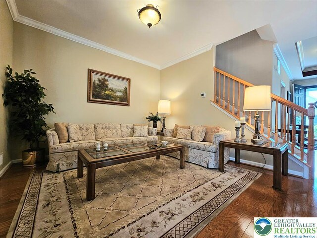living area with crown molding, baseboards, wood-type flooring, and stairs