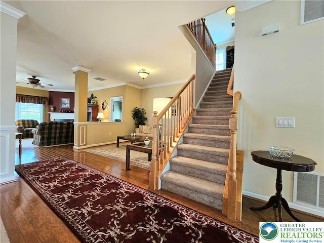 stairs featuring crown molding, ceiling fan, hardwood / wood-style flooring, and visible vents