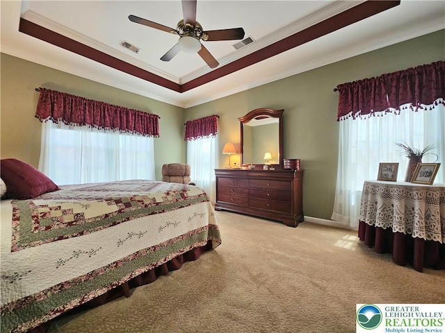 bedroom with crown molding, visible vents, and a raised ceiling