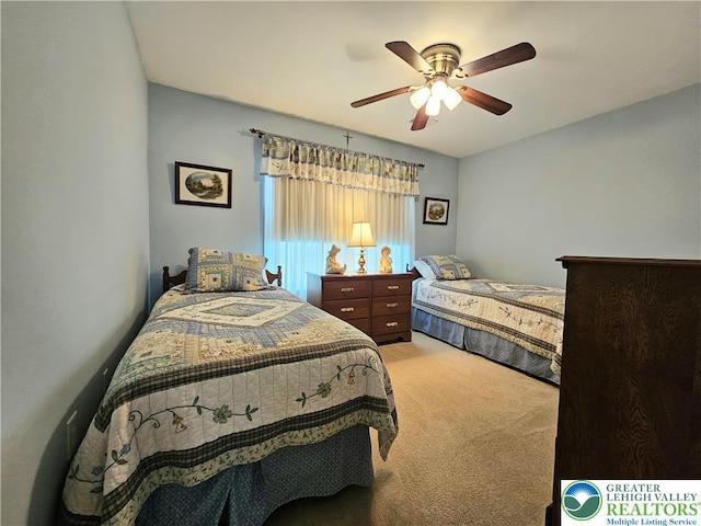 bedroom featuring light colored carpet and a ceiling fan
