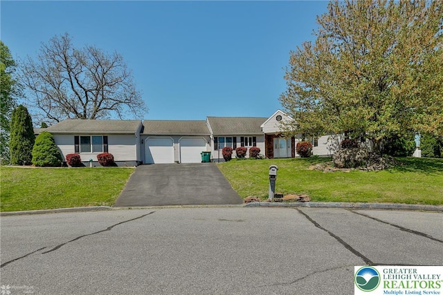 view of front of property featuring an attached garage, a front lawn, and aphalt driveway