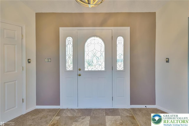 foyer featuring baseboards