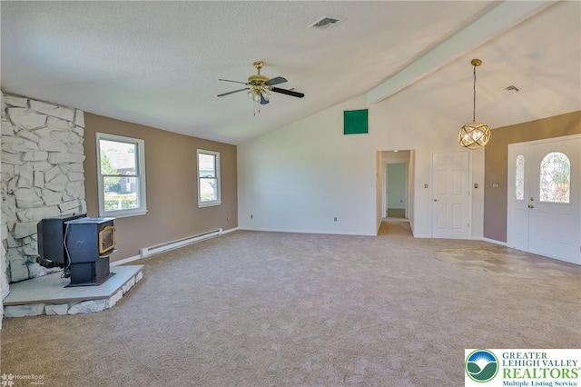 unfurnished living room featuring visible vents, a wood stove, carpet flooring, lofted ceiling with beams, and a baseboard radiator