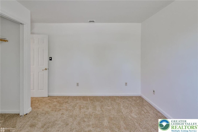 empty room with carpet floors, baseboards, and visible vents