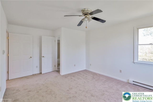 unfurnished bedroom with carpet floors, baseboard heating, and multiple windows