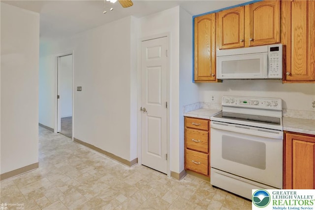 kitchen with brown cabinetry, a ceiling fan, light countertops, baseboards, and white appliances