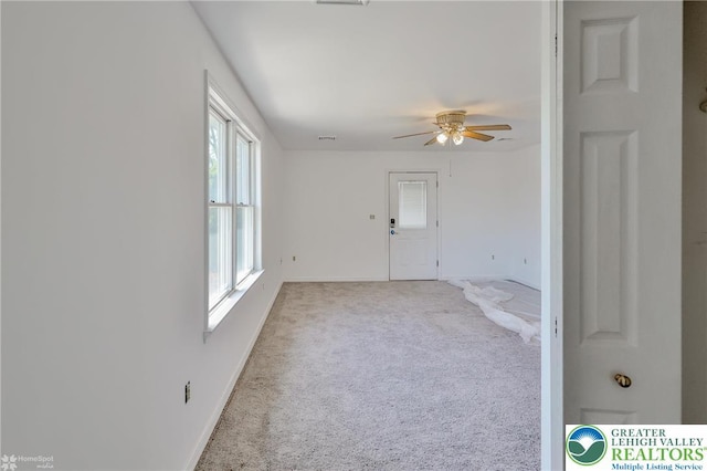 empty room featuring ceiling fan, baseboards, and carpet