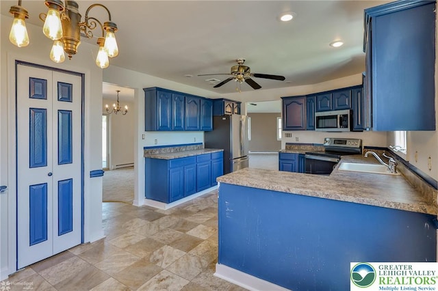 kitchen featuring blue cabinetry, appliances with stainless steel finishes, a sink, ceiling fan with notable chandelier, and a peninsula