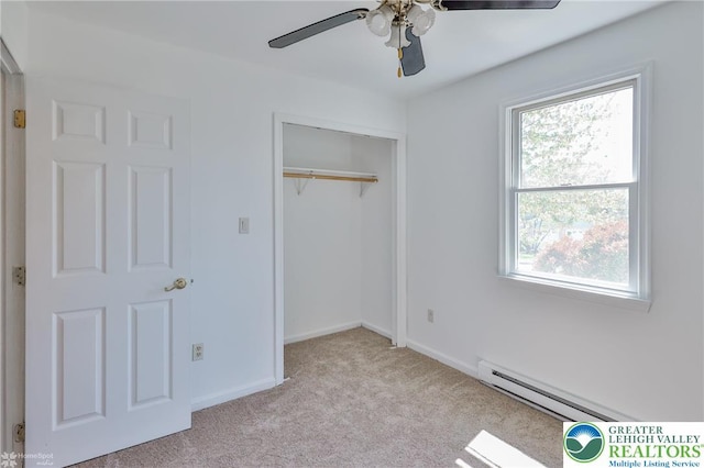 unfurnished bedroom with carpet floors, baseboards, a baseboard heating unit, and a closet
