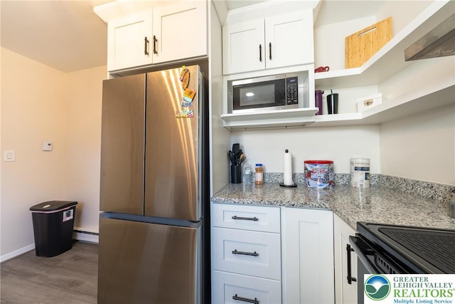 3040 Keystone St, Bethlehem Twp, PA 18020 - kitchen with wood finished floors, light stone countertops, a baseboard heating unit, white cabinets, and stainless steel appliances