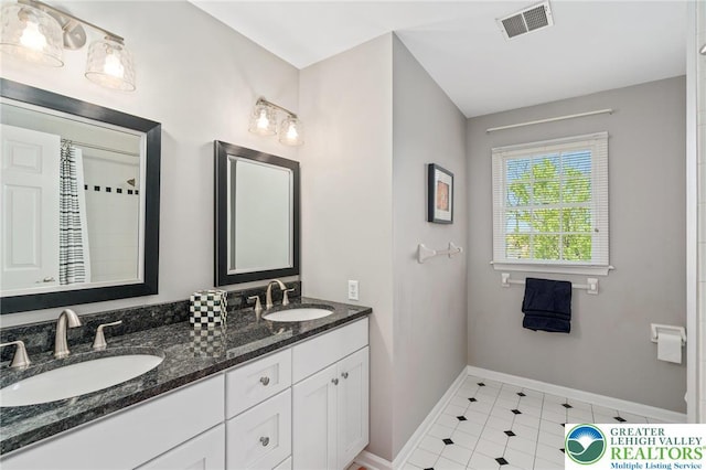 full bath with visible vents, a sink, baseboards, and double vanity