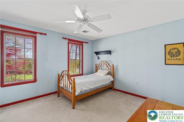 carpeted bedroom with baseboards, a ceiling fan, and visible vents
