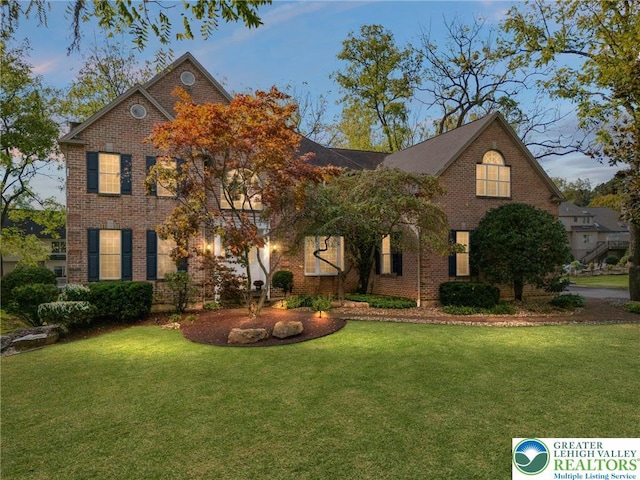 view of front facade with a front lawn and brick siding
