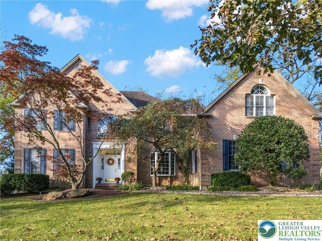view of front of house with brick siding and a front yard