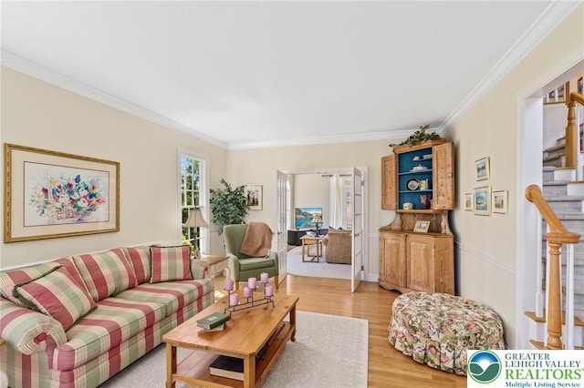 living area featuring crown molding, stairway, and light wood-type flooring