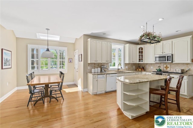 kitchen featuring open shelves, decorative backsplash, white dishwasher, and stainless steel microwave