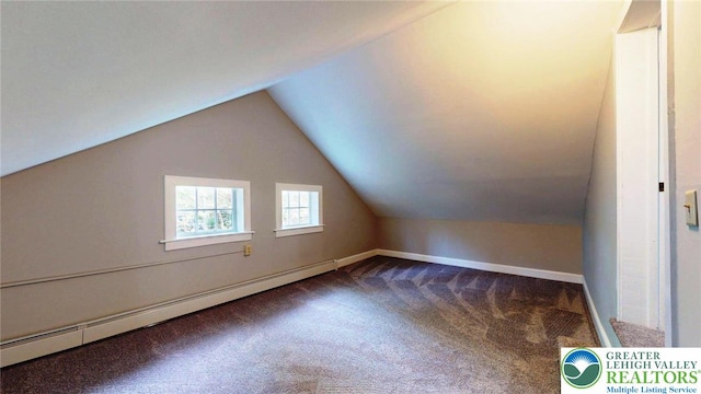 additional living space with baseboards, a baseboard radiator, vaulted ceiling, and dark carpet
