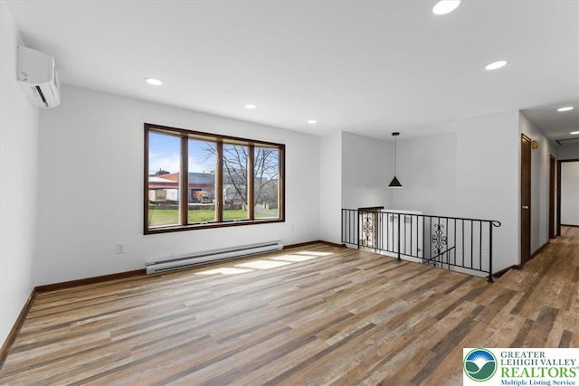 unfurnished room featuring wood finished floors, baseboards, recessed lighting, a wall mounted AC, and a baseboard radiator