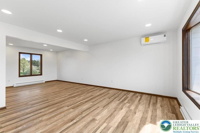 unfurnished room with baseboards, a wall mounted air conditioner, baseboard heating, recessed lighting, and light wood finished floors