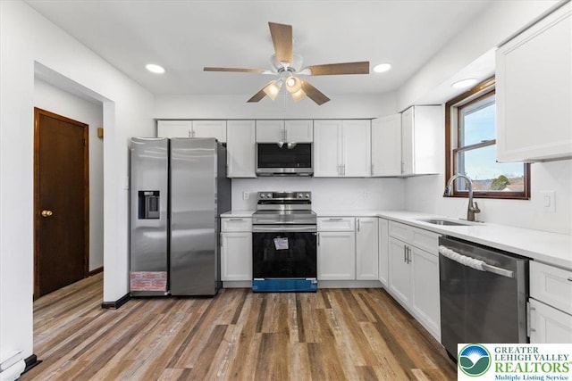 kitchen with ceiling fan, light countertops, white cabinets, a sink, and stainless steel appliances