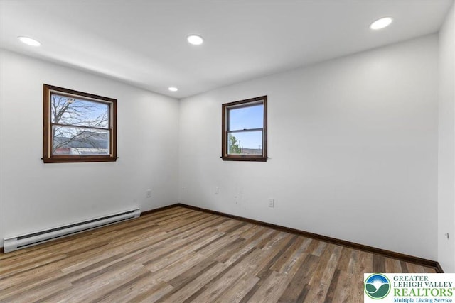 unfurnished room with baseboards, baseboard heating, recessed lighting, and wood finished floors