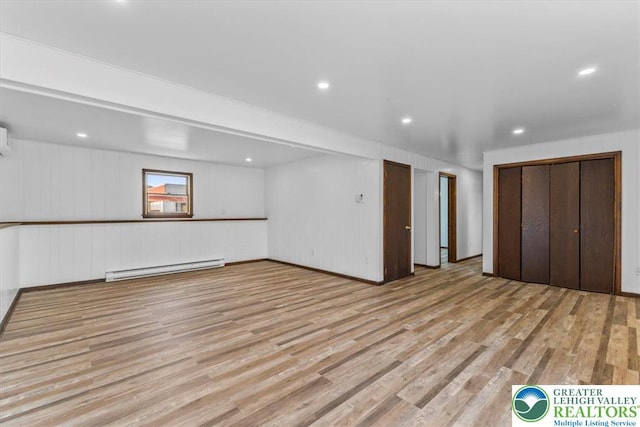 below grade area with recessed lighting, baseboard heating, and light wood finished floors
