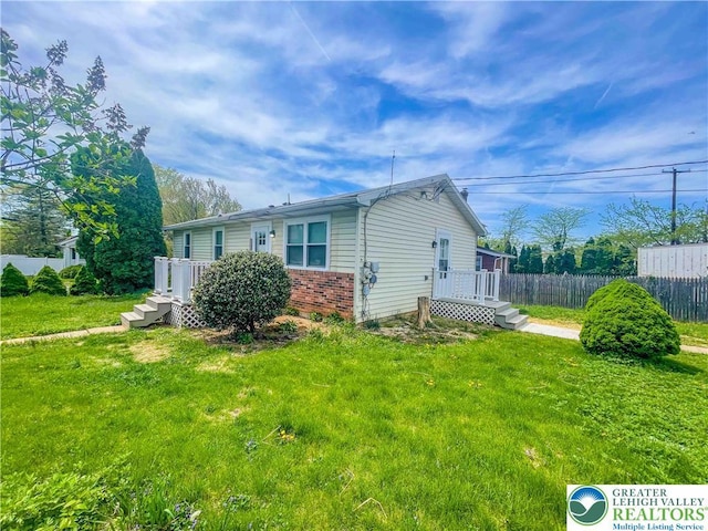 1231 Fairmount St, Bethlehem City, PA 18017 - view of home's exterior featuring a lawn, brick siding, fence, and a deck