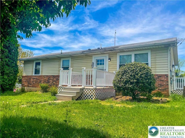 1231 Fairmount St, Bethlehem City, PA 18017 - view of front of home featuring brick siding, a front lawn, and a deck