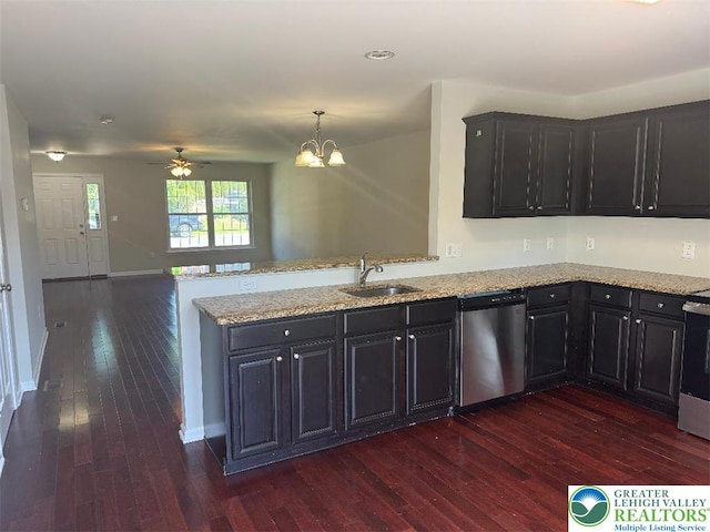 kitchen with light stone counters, a sink, dark wood finished floors, a peninsula, and stainless steel dishwasher