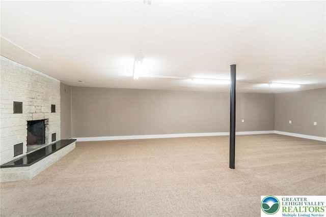 finished basement featuring carpet flooring, baseboards, and a fireplace