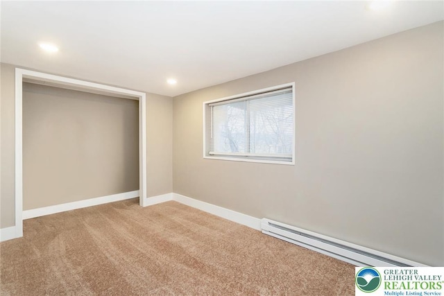 unfurnished bedroom with baseboards, light colored carpet, baseboard heating, and a closet