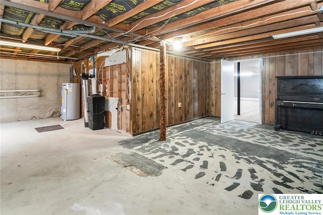 unfinished below grade area featuring wooden walls and water heater