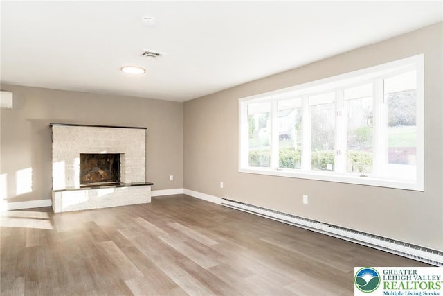 unfurnished living room featuring a brick fireplace, wood finished floors, baseboards, a baseboard radiator, and recessed lighting