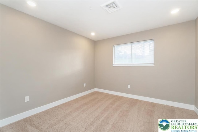 empty room featuring light colored carpet, baseboards, visible vents, and recessed lighting