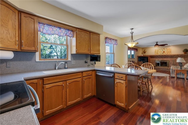 kitchen featuring a sink, a peninsula, dishwasher, and light countertops