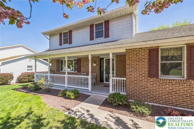 traditional-style home featuring a porch and brick siding